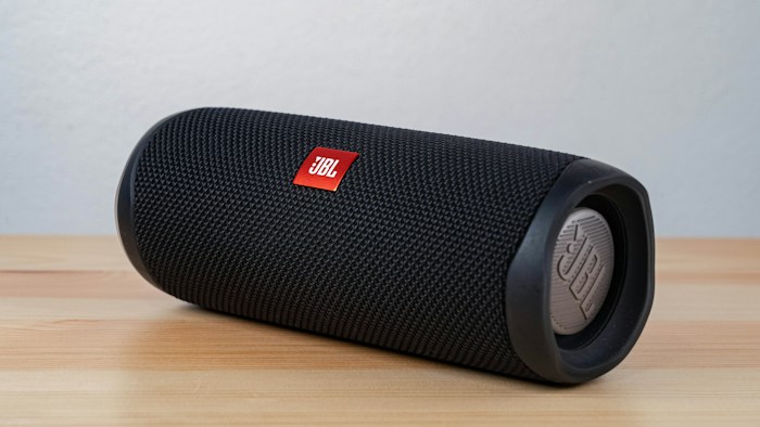 Enceinte noire compacte posée sur une table en bois