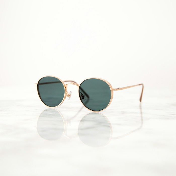 Lunettes rondes à monture fine posées sur une surface claire